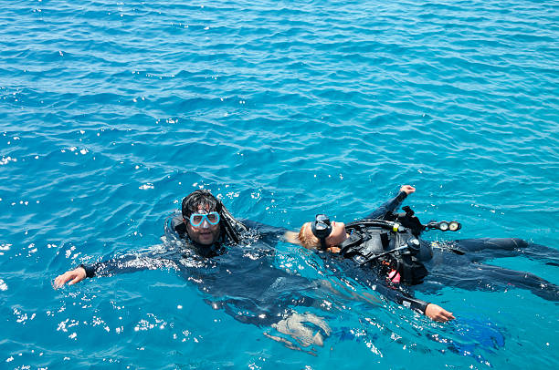 Scuba diver towing a a rescued diver on the surface.